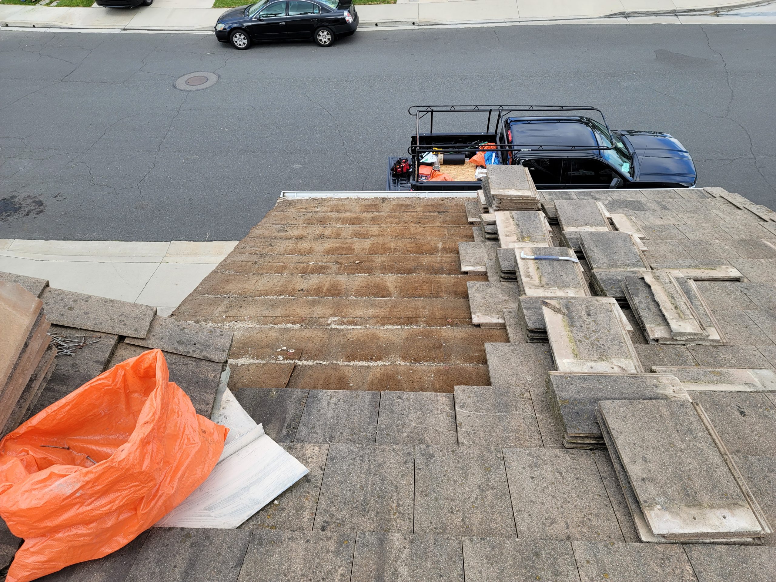 tile roof leak detection showing underlayment exposure beneath concrete tiles